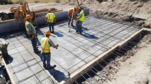 construction-workers-inspecting-rebar-grid-concrete-slab